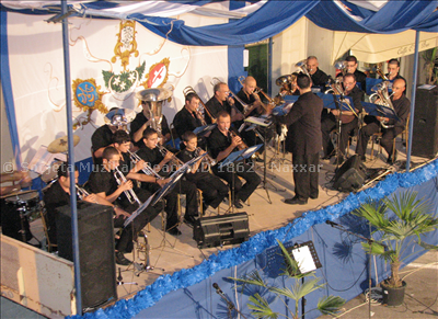 Il-brass band tas-Soċjeta ddoqq siltiet mill-aqwa. 